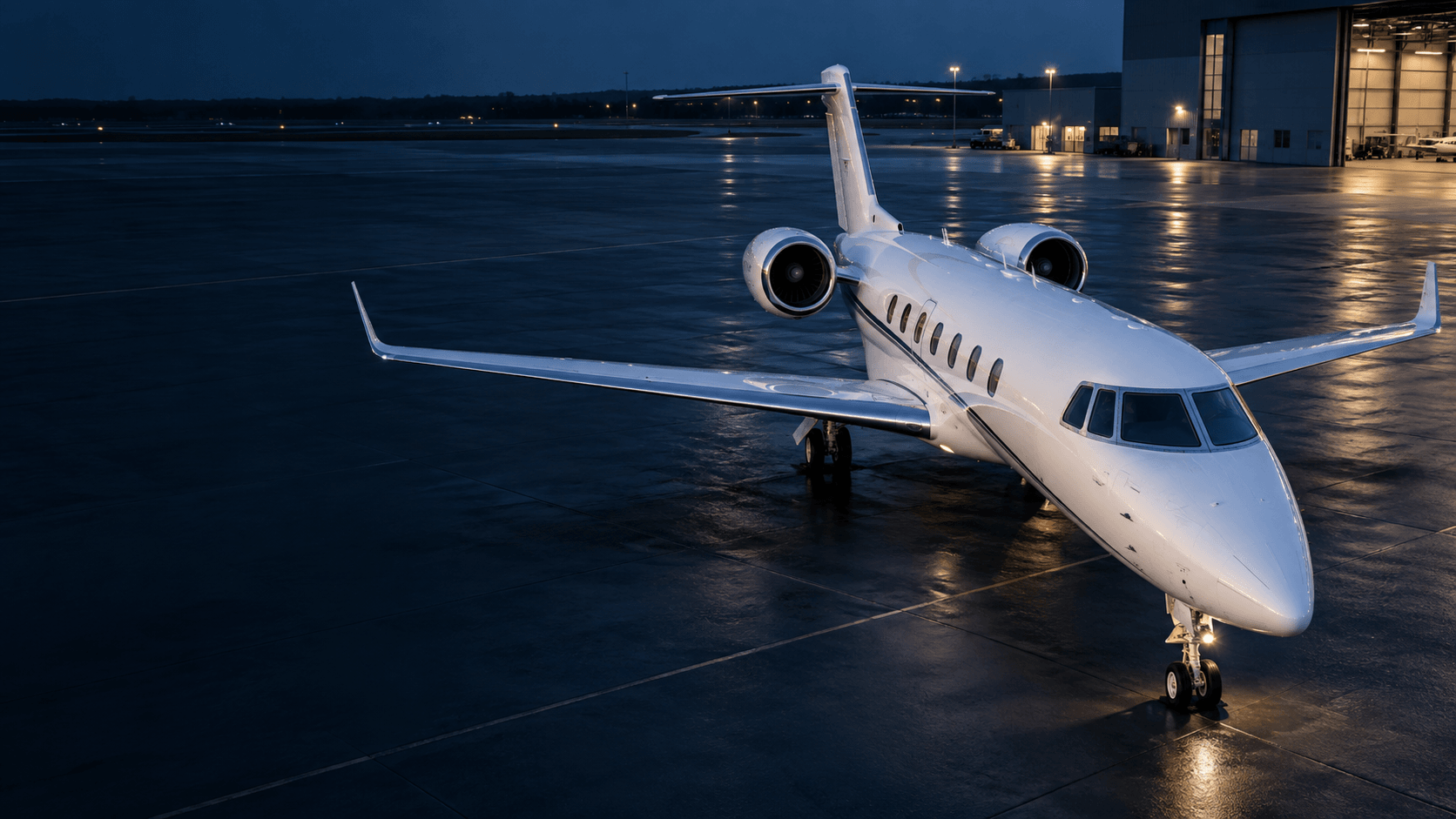 A business jet on an illuminated apron at dusk